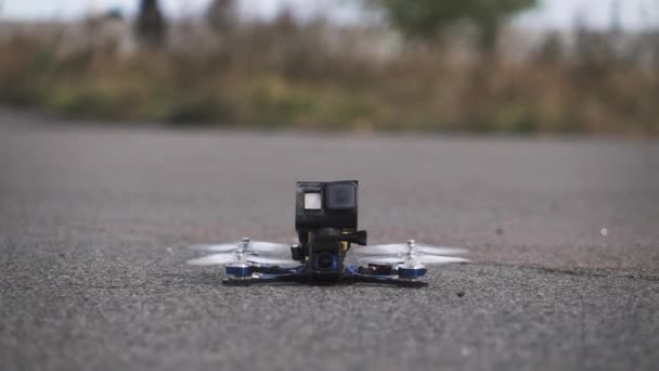 Drone de carreras FPV despega de la superficie de asfalto — Vídeo de stock