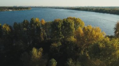 Hava aracı görüntüleri. Sonbahar mevsiminde Kyiv şehri manzaralı Dnipro nehri üzerindeki ada üzerinde uçuş
