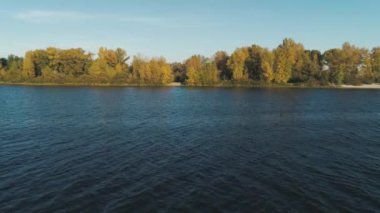Hava aracı görüntüleri. Arka planda nehir suyundan sonbahar adasına alçak uçuş