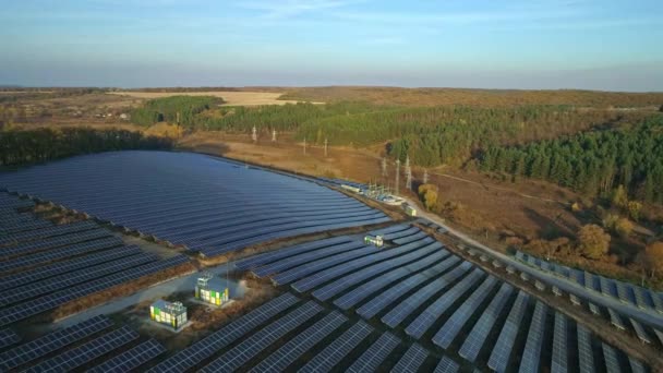 Nagranie z dronów lotniczych. Lot promieniowy nad farmą paneli słonecznych o zachodzie słońca jesienią. — Wideo stockowe