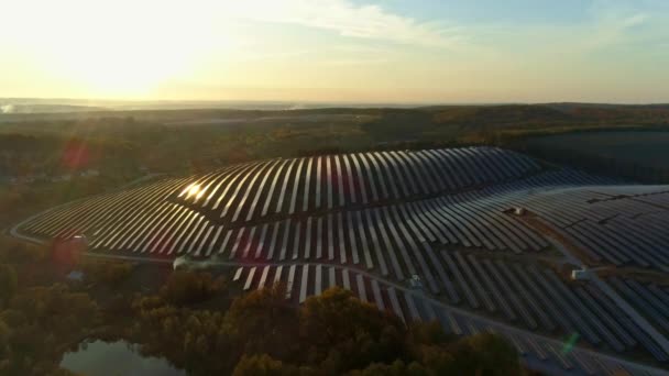 Nagranie z dronów lotniczych. Lot na farmę stacji słonecznej o zachodzie słońca jesienią — Wideo stockowe
