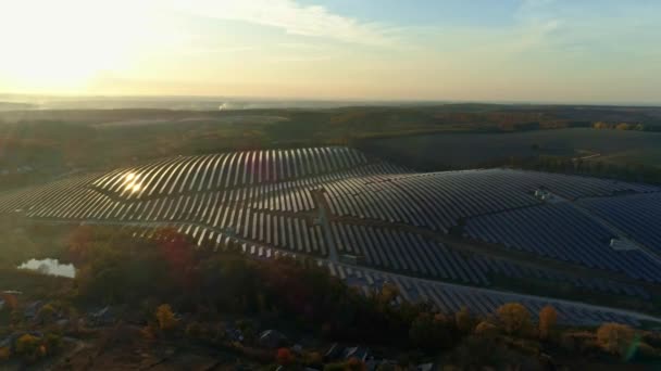 Aerial drone footage. Backward flight over solar panel farm at sunset autumn season. — Stock video