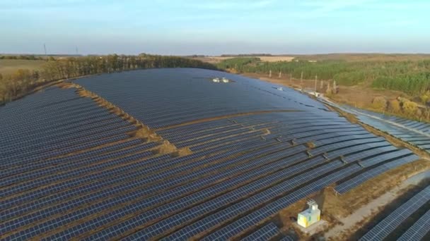 Nagranie z dronów lotniczych. Lot nad farmą paneli słonecznych o zachodzie słońca jesienią. — Wideo stockowe