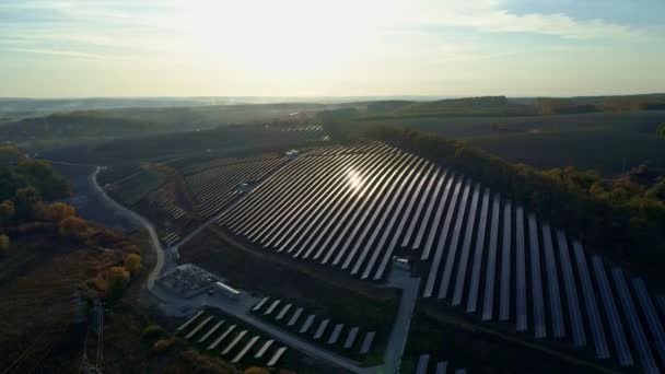Drohnenaufnahmen aus der Luft. Radialflug über Solarpaneelfarm bei Sonnenuntergang im Herbst. — Stockvideo