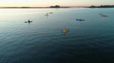 Hava aracı görüntüleri. Bir grup turist kayak yapıyor. Nehrin üzerinde güzel bir gün doğumu