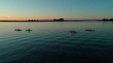 Hava aracı görüntüleri. Bir grup turist kayak yapıyor. Nehrin üzerinde güzel bir gün doğumu