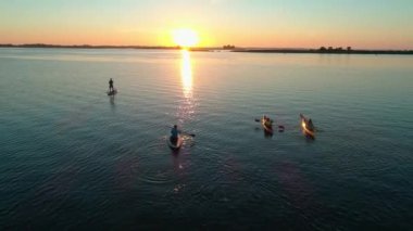 Hava aracı görüntüleri. Bir grup turist kayak yapıyor. Nehrin üzerinde güzel bir gün doğumu