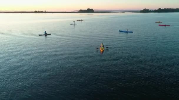 Drohnenaufnahmen aus der Luft. Eine Gruppe Touristen ist mit dem Kajak unterwegs. Schöner Sonnenaufgang über dem Fluss — Stockvideo