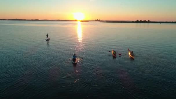 Légi felvétel. Egy csapat turista kajakozik. Gyönyörű napkelte a folyó felett — Stock videók