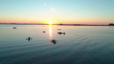 Hava aracı görüntüleri. Bir grup turist kayak yapıyor. Nehrin üzerinde güzel bir gün doğumu