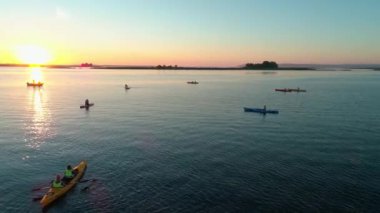 Hava aracı görüntüleri. Bir grup turist kayak yapıyor. Nehrin üzerinde güzel bir gün doğumu