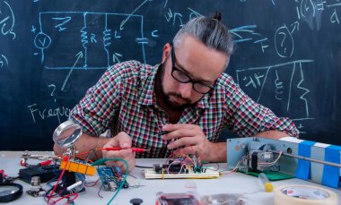Elektrikli cihazlar üzerinde çalışan odaklanmış ve çok düşünen teknisyen