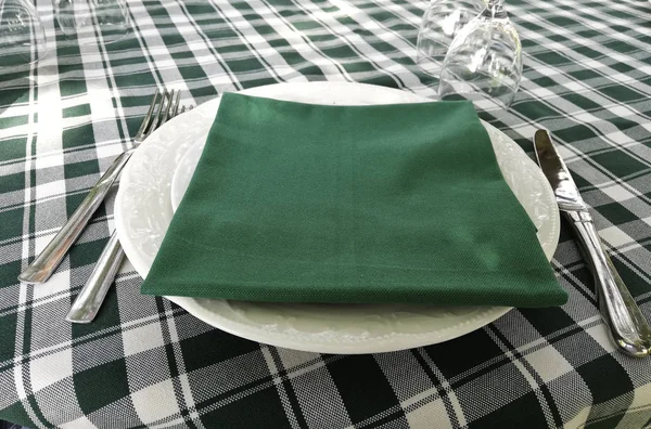 typical white and green tablecloth laid on a restaurant table