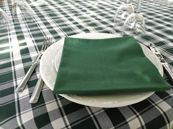 typical white and green tablecloth laid on a restaurant table