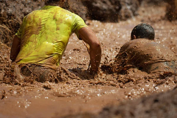 泥赛跑赛跑者 在极端障碍比赛期间 — 图库照片