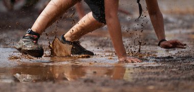 Çamur yarışı koşucuları. Emekliyor, dikenli tellerin altından geçiyor. Engelli yarış sırasında engeller çıkıyor.