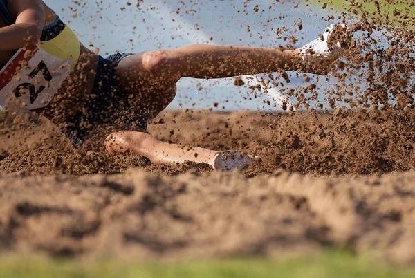 Atlet Wanita Melompati Pendaratan Lompat Jauh Lapangan Pasir — Stok Foto