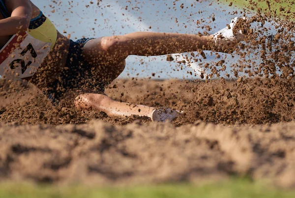 Mulher Atleta Pulando Salto Longo Pouso Areia — Fotografia de Stock