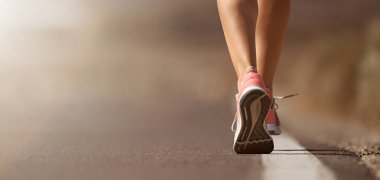 Spor ayakkabılarıyla koşan bir kadının koşu ayakkabısı.