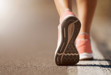 Spor ayakkabılarıyla koşan bir kadının koşu ayakkabısı.