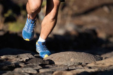 Ayak runner atlet orman içinde iz taşlar üzerinde çalışan