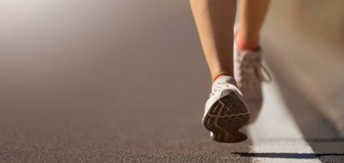 Spor ayakkabılarıyla koşan bir kadının koşu ayakkabısı.