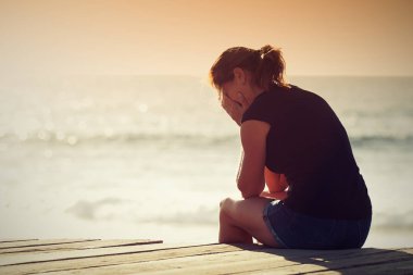 Üzgün kadın endişeli siluet güneş batımında sahilde