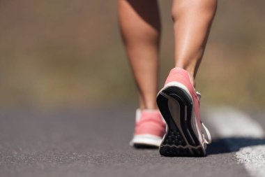 Spor ayakkabılarıyla koşan bir kadının koşu ayakkabısı.