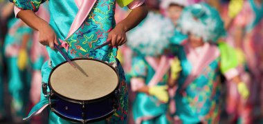 Carnival music played on drums by colorfully dressed musicians clipart