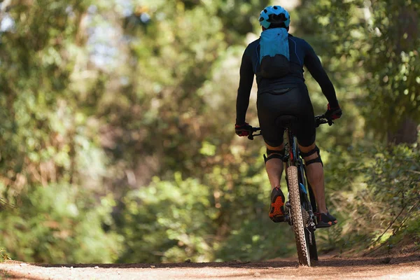 Mountain biking man riding on bike in summer mountains forest landscape