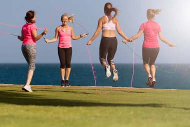 Deniz de fitness eğitimini yapan bir grup genç, ip atlama kullanarak