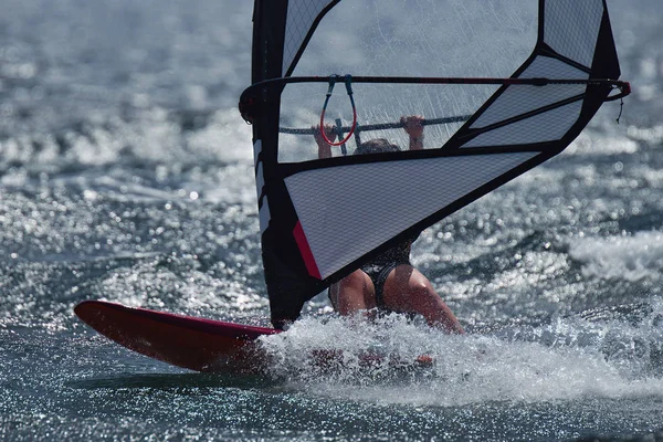 Windsurfer surfing the wind on waves in ocean sea