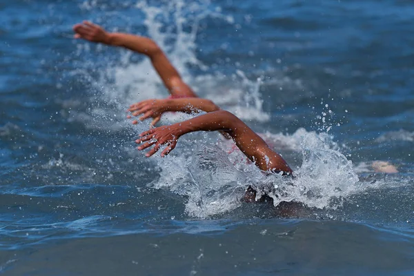 Athletes swimming in a competition swimming at triathlon