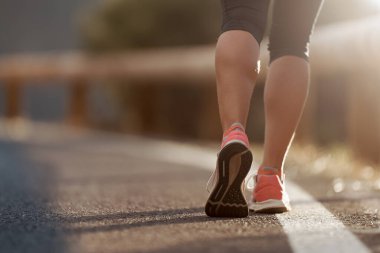 Spor ayakkabılarıyla koşan bir kadının koşu ayakkabısı.