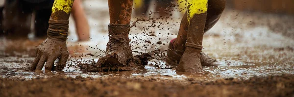 泥レースのランナークロール 極端な障害物レース中に有刺鉄線障害物の下を通過 — ストック写真