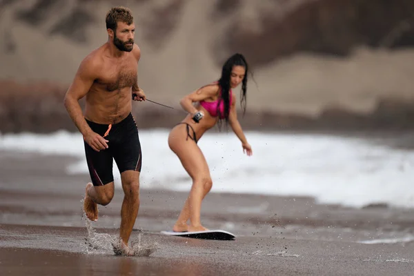 Young Man Pulls Young Girl Rope Who Learning Skimboard — Stock Photo, Image