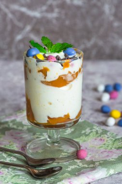 Beyaz çikolatalı dondurma ve çikolata yumurta ve taze nane ile süslenmiş karamelli tatlı