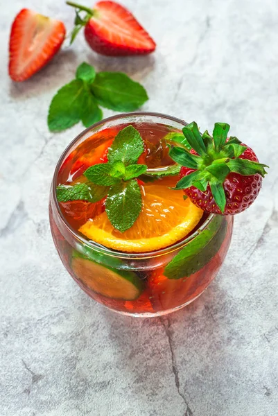 Traditional Pimms cocktail with lemonade, strawberries, cucumber, orange and mint
