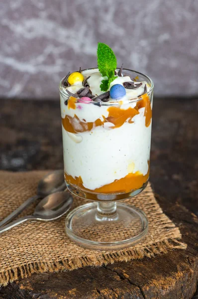 Beyaz çikolatalı dondurma ve çikolata yumurta ve taze nane ile süslenmiş karamelli tatlı