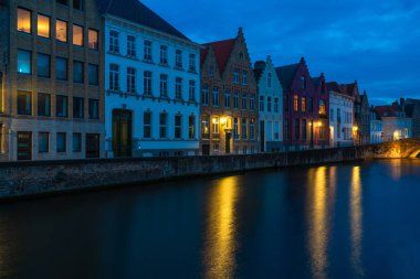 Bir kanal ve alacakaranlıkta Bruges, Belçika eski tarihi binaların görünümü
