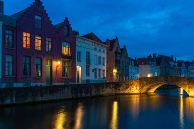 Bir kanal ve alacakaranlıkta Bruges, Belçika eski tarihi binaların görünümü