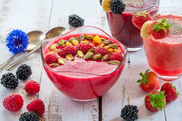 Ahududu, çilek ve böğürtlen smoothies taze meyve ve antep fıstığı ile süslenmiş. Sağlıklı kahvaltı fikir.