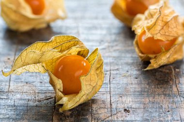 Physalis meyve kabuğu ahşap arka plan - portre üzerinde (Physalis Peruviana)