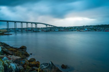 Tromso köprüden Tromsoysundet gece karanlığında Norveç'te boğaz manzarası. Tromsdalen anakara üzerinde ile Tromsoya Adası üzerinde Tromso bağlanır
