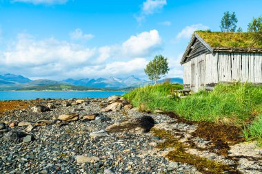Eski ahşap kulübe taşlı beach ve Tromsoya, Norveç adada fiyort