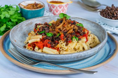 Kushari - Mısır vejetaryen tabağı ile mercimek, kızarmış soğan ile tepesinde makarna ve domates sosu baharatlı