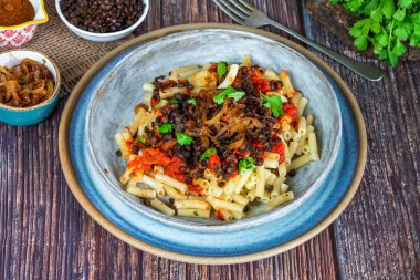 Kushari - Mısır vejetaryen tabağı ile mercimek, kızarmış soğan ile tepesinde makarna ve domates sosu baharatlı