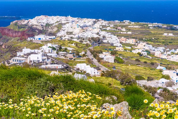 View of Oia, a coastal town on Greek island Santorini. The town has whitewashed houses carved into the rugged clifftops.