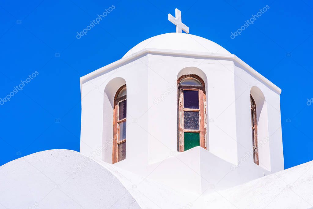 A dome of a traditional whitewashed Greek church agaimst blue sky, Santorini, Greece