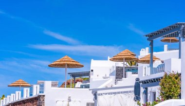 Santorini Yunan adasında geleneksel beyaz badanalı evlerin dışında Parasoles - tatil ve açık yaşam